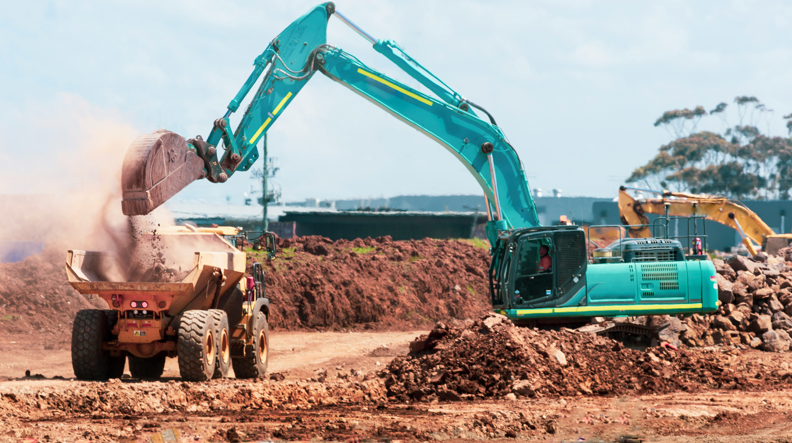 imagem de pessoas trabalhando com retroescavadeira em terreno